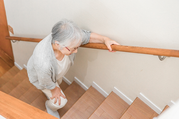 足を押さえて階段を上る女性